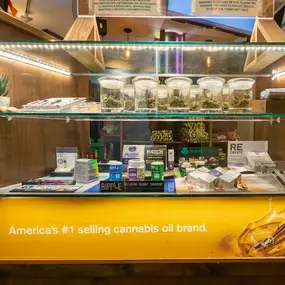 Glass display case featuring cannabis flower, edibles, and branded products at Lightshade dispensary.