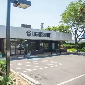 Exterior view of Lightshade Dayton Rec & Med Dispensary with signage, parking spaces, and greenery.