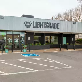 Exterior of Lightshade Dayton dispensary featuring signage, a parking lot, and entrance.