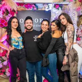 Group of guest take a photo in front of Oxford Social club's flower wall 