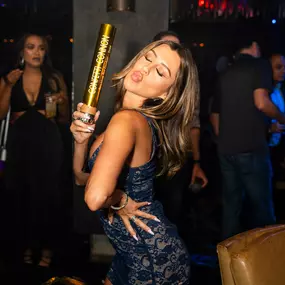 bottle girl holding confetti cannon while having fun at Oxford Social Club