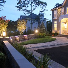Pavers, paver ledge wall with fountain spillover accented by lighting at night