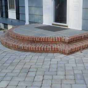 Backdoor entrance with pavers, brick and stone
