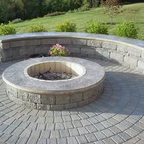 Circular fire pit with low retaining wall which can be used for seating