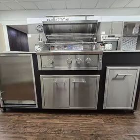 Sleek and compact XO outdoor grilling island featuring a stainless steel built-in gas grill, storage drawers, and refrigerator – ideal for luxury outdoor cooking setups, displayed at Art Handler’s Appliance showroom.