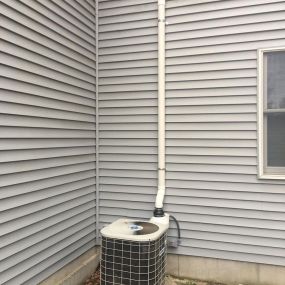 Hiding the radon system fan behind an air conditioner condenser.