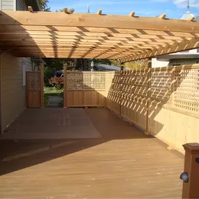 A custom ground-level cedar deck with an overhead pergola built by Cedar Works in Bloomfield Hills, MI. Designed for elegance and shade, this outdoor living space blends beauty, craftsmanship, and function.