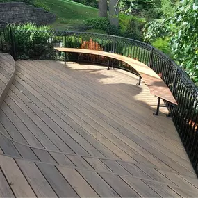 A beautifully crafted custom curved deck with sleek black metal fencing by Cedar Works in Bloomfield Hills, MI—designed to blend modern style with outdoor functionality.