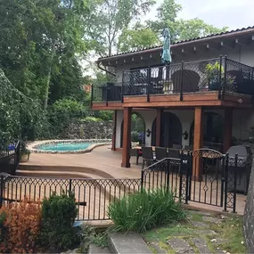 A custom two-story deck with elegant black metal railings built by Cedar Works in Bloomfield Hills, MI. Featuring a curved lower-level pool deck and an upper deck for entertaining, this outdoor space seamlessly blends luxury, function, and craftsmanship.