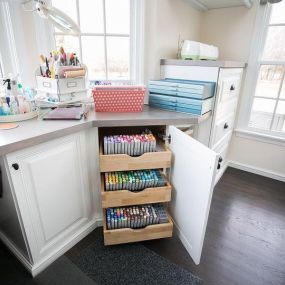 Custom-sized pullouts allow you to size your storage to fit any material, as shown in this Craft Room. Our designers help you decide where and how to store your materials so you can easily find just what you need. #TailoredLivingNorthTampa #FreeConsultation #CraftOrganization #TailoredToYourNeeds