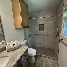 Walk-in shower complete with grab bars inside the shower and on the side of the vanity. A wonderful ADA compliant design.