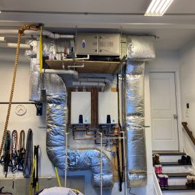 Converted an older boiler, indirect water heater, and hydro coil located in the customer’s attic to two conventional forced hot air Carrier Furnaces, two Carrier Coils, and two Carrier Condensers with twinned Navien Combi Tankless Water Heaters relocated in the garage.