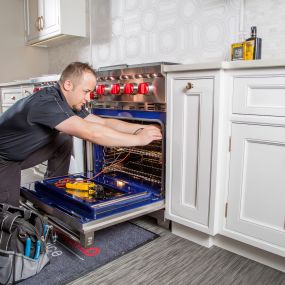 A technician repairs a Wolf oven.