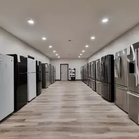 A sleek aisle view of Lehigh Supply Appliances’ refrigerator section, showcasing a full lineup of top-freezer, French door, and side-by-side models.