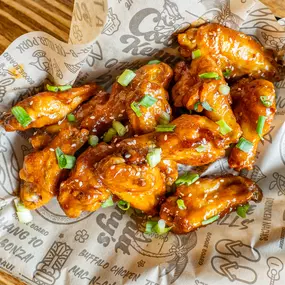 Oven-baked wings tossed in honey sesame sriracha dressing – sprinkled with green onions and toasted sesame seeds.