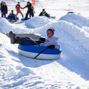 Enjoy the crisp alpine air on a snow tube at Grizzly Ridge Tube Park.