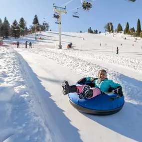 Smile for days as you race down the winter tube lanes at Grizzly Ridge Tube Park.