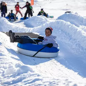 Enjoy the crisp alpine air on a snow tube at Grizzly Ridge Tube Park.