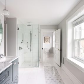 This master bathroom remodeling project in Ardmore includes tile details such as SOHO Studio Metrology Thassos Carrara marble area rug feature and Maiolica White Ceramic Glossy Wall Tile 4x10 subway wall tiles. Polished chrome fixtures include Newport Brass shower controls, Moen Immersion shower hea