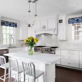 Haverford kitchen remodel with marble counter tops, marble subway tile backsplash in herringbone pattern, and random width hardwood flooring.