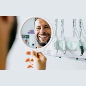 Man looking at his white teeth in a mirror