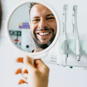 Man looking at his white teeth in a mirror