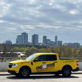 A One Hour truck on the road with the Downtown Fort Worth TX skyline in the background