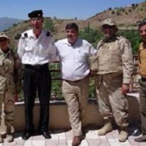 Pic­tured: Cap­tain Steve Had­dad (second from right) with mem­bers of his unit and some loc­als in Ir­aq.