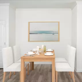 Open kitchen and dining area with wood-inspired flooring.