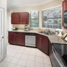 Estate style kitchen with chestnut cabinets tile floors stainless steel appliances and glass cooktop