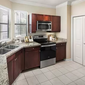 Estate style kitchen alongside laundry area with full size washer and dryer