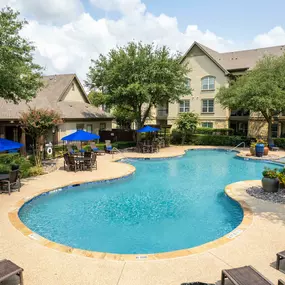 Second pool with sundeck loungers and tables with umbrellas