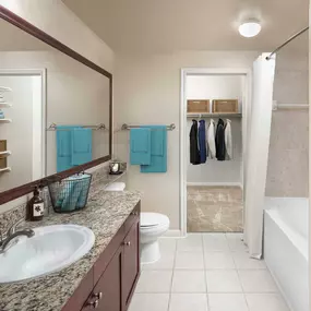 Estate style bathroom with walk in closet tile flooring granite countertops and framed mirror