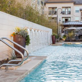 Resort style pool fountain with outdoor seating