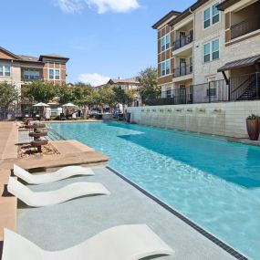 Resort-style pool with in-water loungers at Camden La Frontera