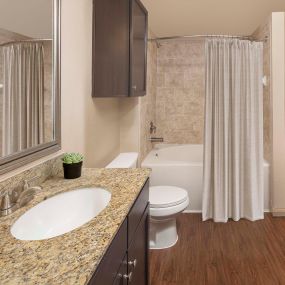 Bathroom with granite countertops and soaking bathtub at Camden La Frontera