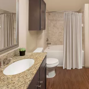 Bathroom with granite countertops and soaking bathtub at Camden La Frontera