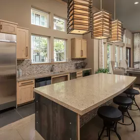 Clubroom entertaining kitchen with full-size appliances and extended island seating at Camden La Frontera apartments in Austin, TX