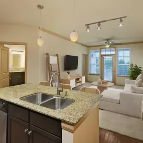 Kitchen and living room with island and private balcony at Camden La Frontera apartments in Round Rock, TX