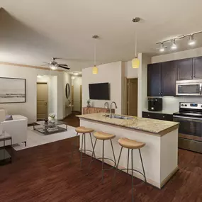 Open living room and kitchen with wood-style floors at Camden La Frontera apartments in Round Rock, TX