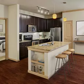 Kitchen with island and stainless steel appliances at Camden La Frontera apartments in Round Rock, TX