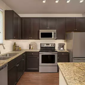 Kitchen with island and granite countertops at Camden La Frontera