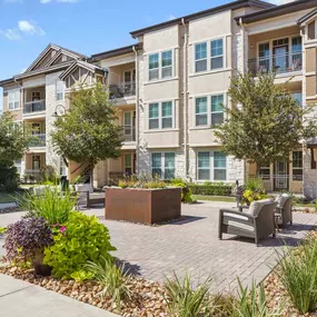 Courtyard with lush landscaping and seating at Camden La Frontera