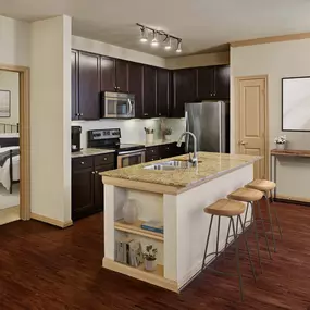 Kitchen with island and stainless steel appliances at Camden La Frontera apartments in Round Rock, TX
