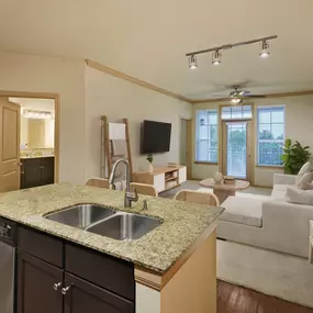 Kitchen and living room with island and private balcony at Camden La Frontera apartments in Round Rock, TX