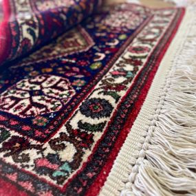Installation of new cotton fringe on an oriental rug.