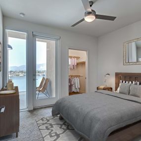 Bedroom with floor to ceiling window and patio and walk in closet and lighted ceiling fan