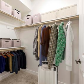 Spacious walk-in closet with wood shelves and rods