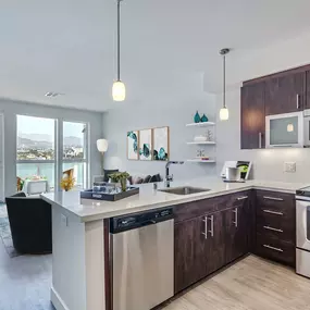 Kitchen with stainless steel appliances wood look flooring and patio views