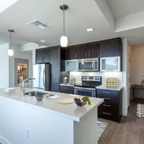 Entry foyer near kitchen with stainless steel appliances and white quartz countertops and island